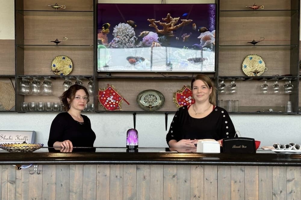 Co-owner of Aladdin Kebab House, Nasreen Iman, right, helps an employee at the front bar.