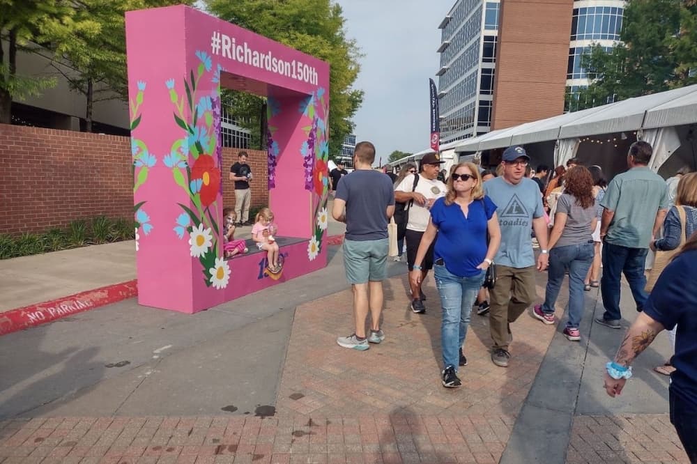 Residents walk past a photo opportunity at Wildflower Festival