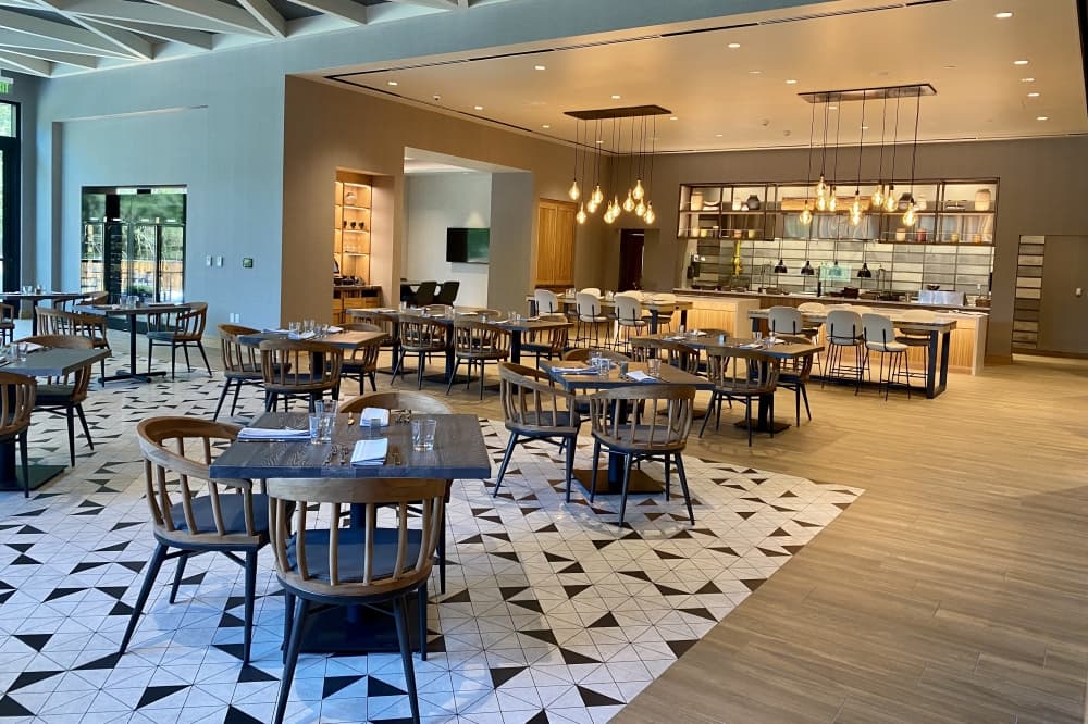 an elegant restaurant with tables and chair and bright chandeliers