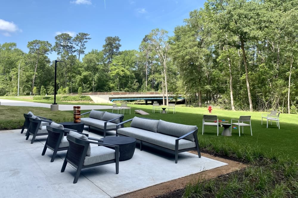 Outdoor lawn with tables, chair, and cornhole. 
