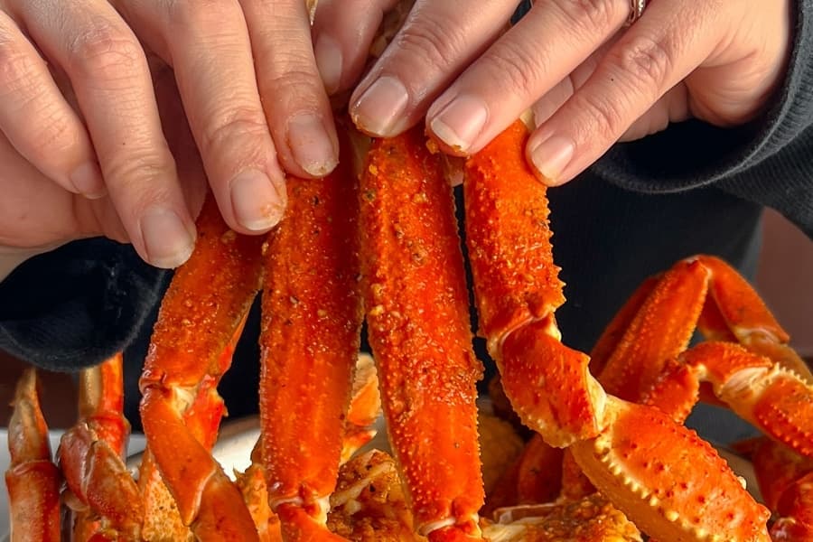 A diner digs in to a boil featuring crab legs. Seafood boil prices range $36-$115, depending on the size of the visiting group and ingredients. (Courtesy Smashin’ Crab)
