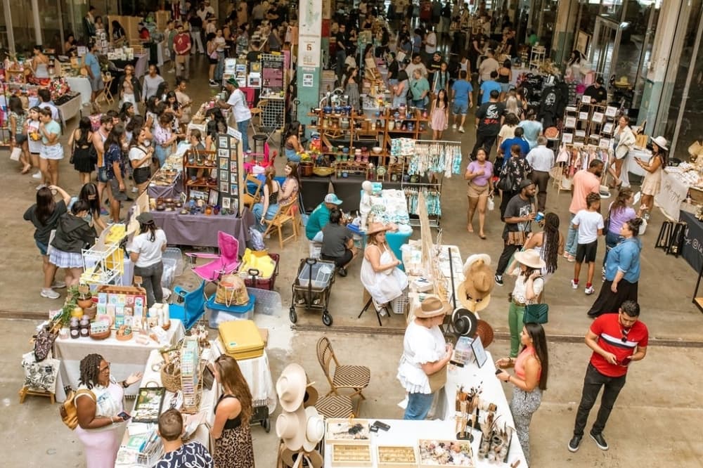 people peruse booths set up at a market