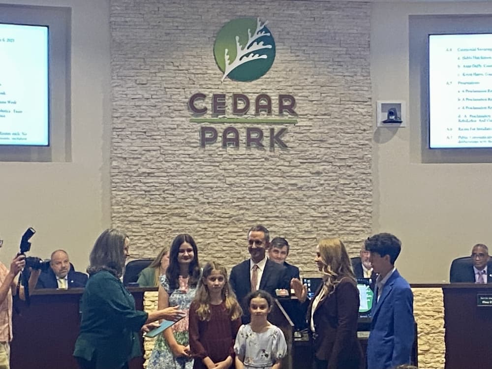 Family at a city council meeting where their mom and wife is being sworn in.
