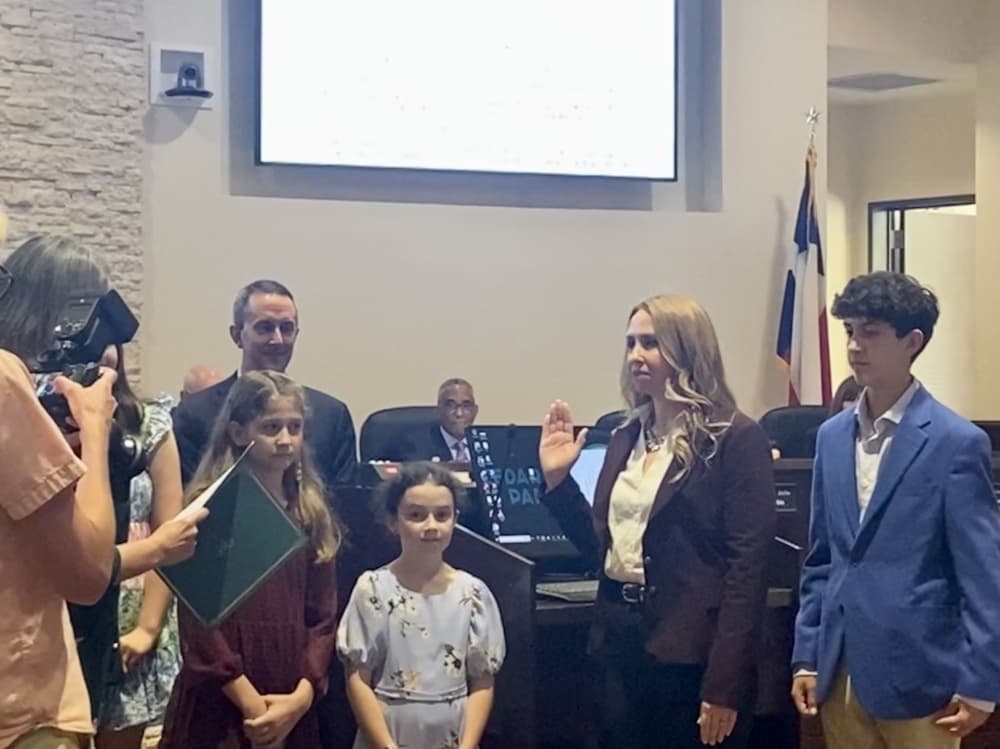 Family at a city council meeting where their mom and wife is being sworn in.