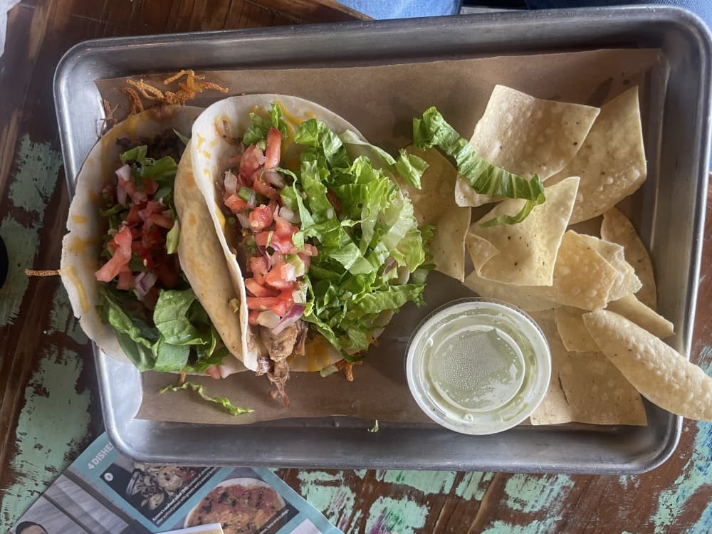 A photo of tacos with a side of chips and salsa 