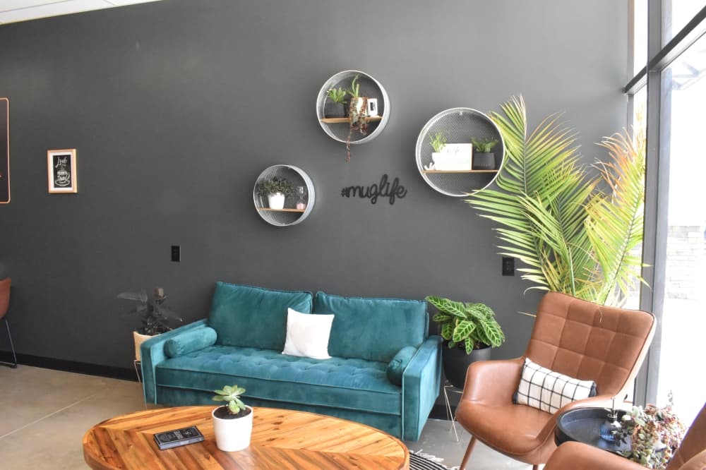 Inside, the restaurant features seating options including brown leather chairs and a bright blue couch. (Lizzy Spangler/Community Impact)