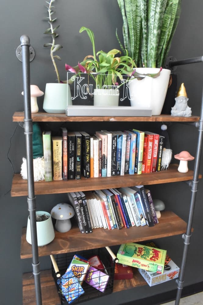 Kolache Kafe features a shelf stocked with games and books for customers. (Lizzy Spangler/Community Impact)