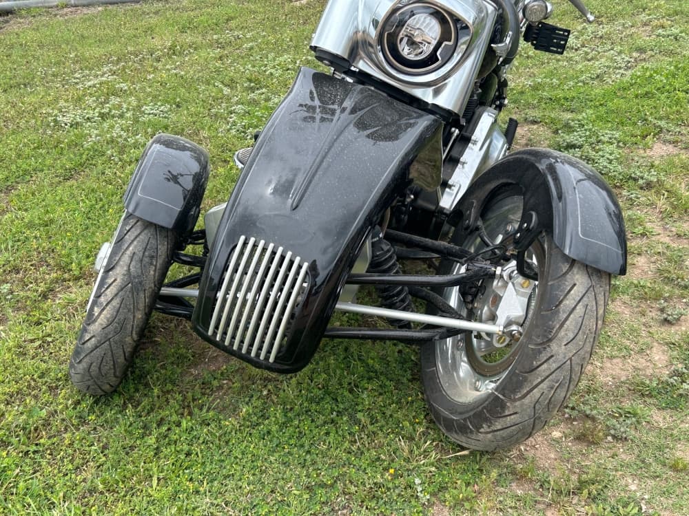 The Tilting Motor Works conversion kits sold by Kline at Flying Piston Motorcycles allow riders to add a wheel to their existing bike for stability. (Brooke Sjoberg/Community Impact)