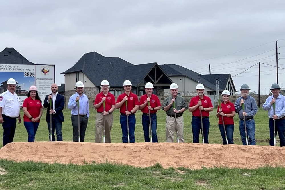Fire station groundbreaking event, people standing with shovels
