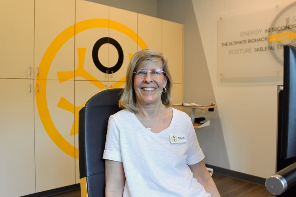 Owner Ellen Allam sitting on a osteogenic loading machine.