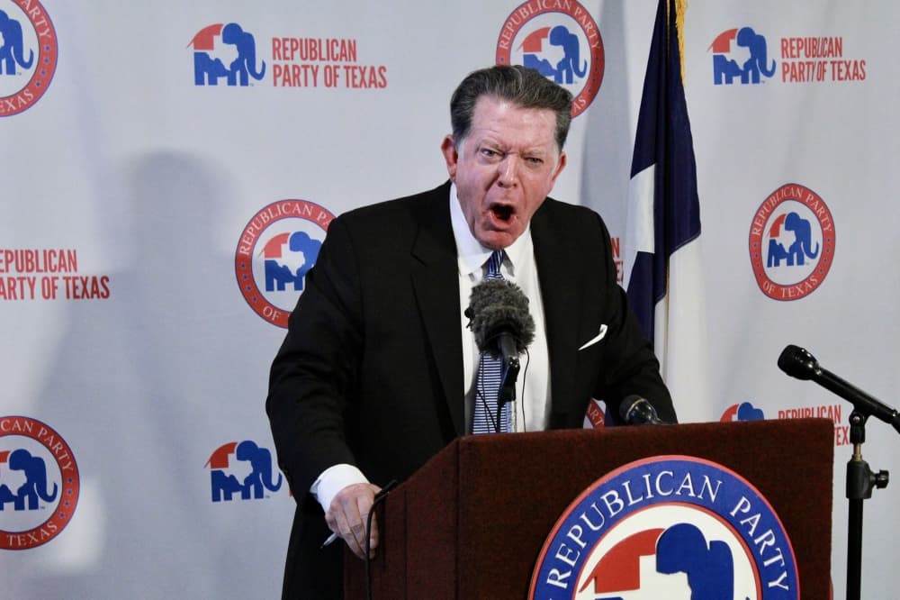 dan cogdell speaks at a podium during a news conference