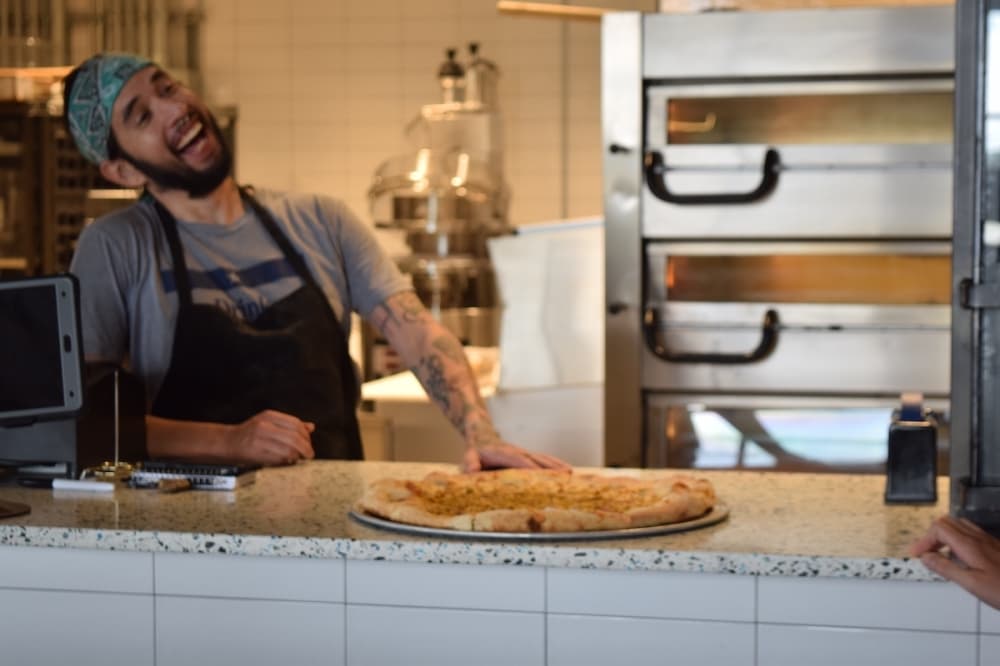 a man offers a pizza