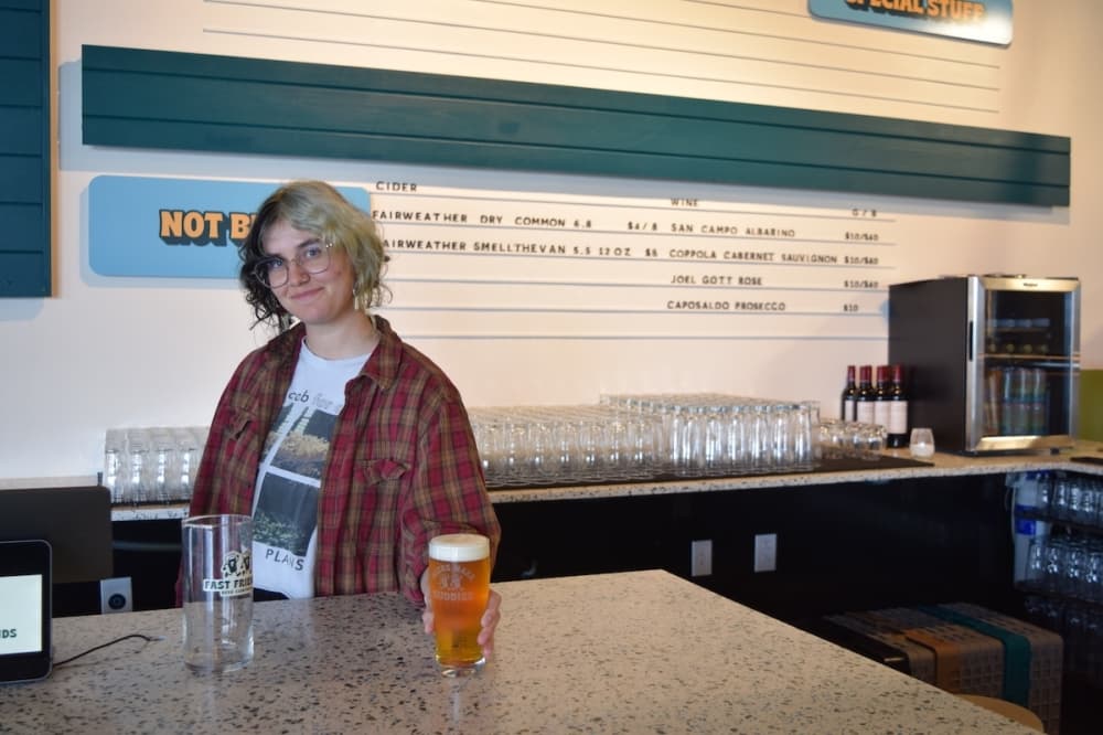 A bartender hands off a beer at the bar