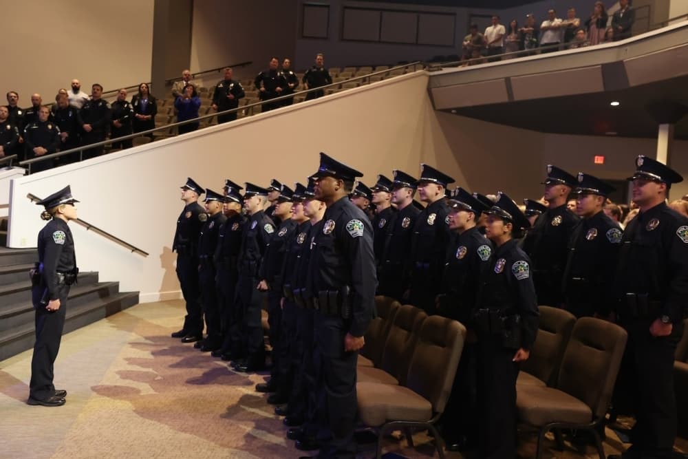 police cadets stand in an auditorium 