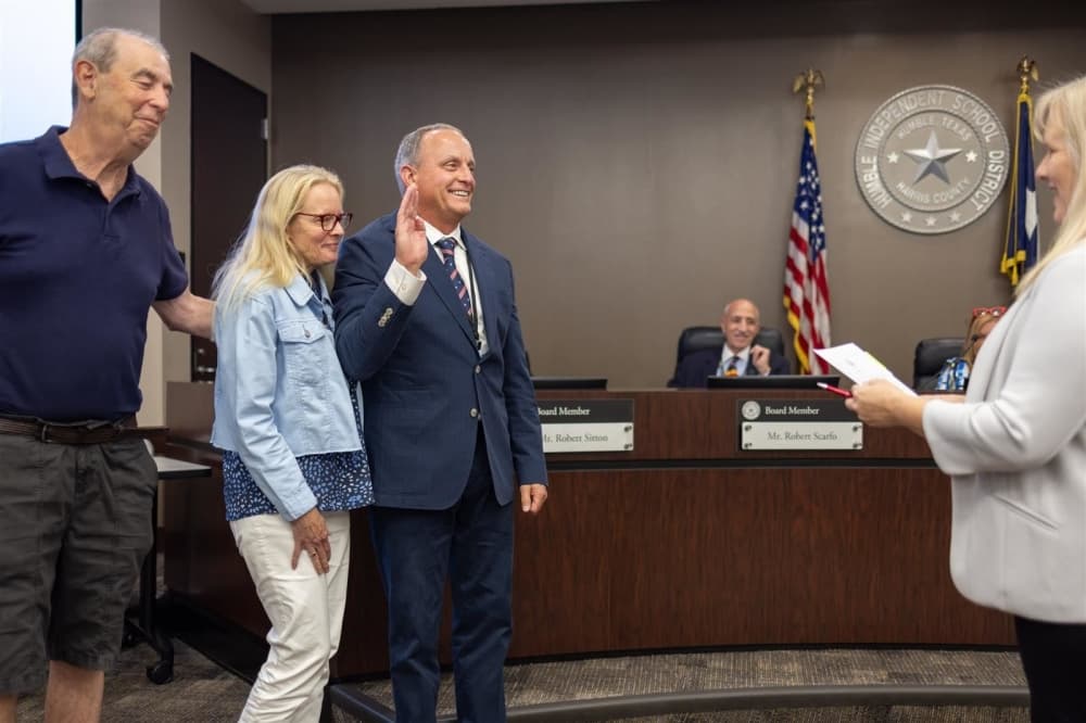 Karen Martin, who serves as the executive secretary to the board of trustees, administers the oath of office to Position 7 Trustee Michael Grabowski during the June 13 board meeting.