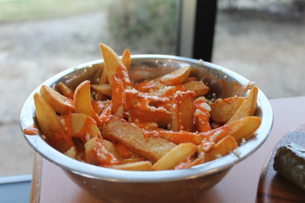 Greek volcano fries are covered with feta cheese and sriracha sauce. (Renee Farmer/Community Impact)