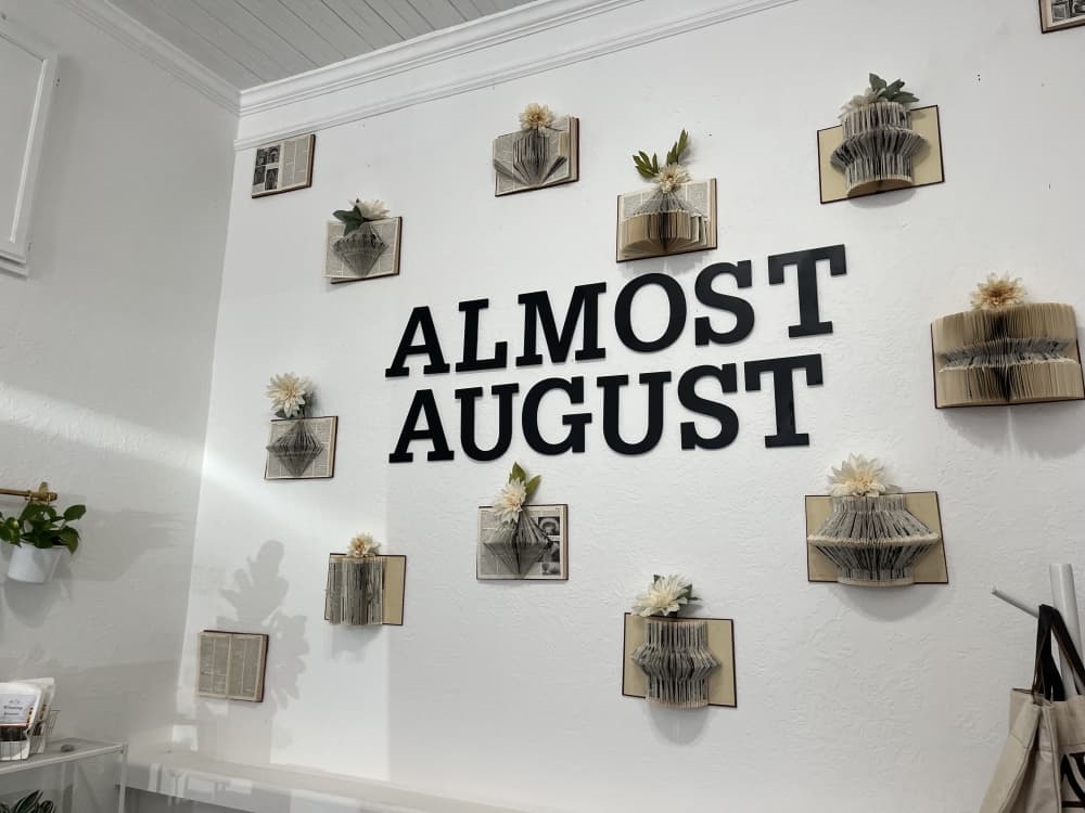 Picture shows a wall with the name of the store in bold black letters. 
