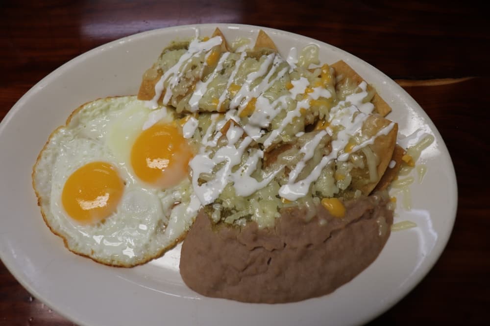 The chilaquiles are topped with green tomatillo sauce, two eggs and refried beans. .69 (Zara Flores/Community Impact)