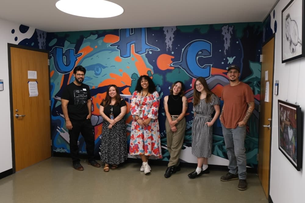 David Moya (left) and Jacob Messa (right) pose with the collaborators of the mural.