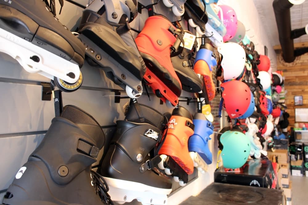 rows of skates and helmets on a wall 