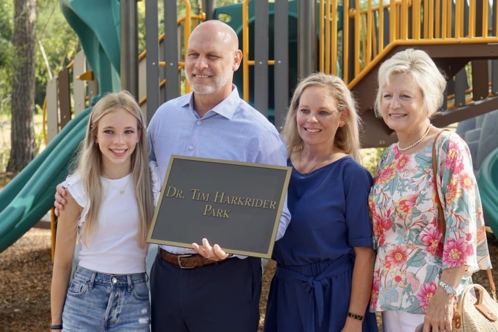 Harkrider holds the park sign with his family. (Cassandra Jenkins/Community Impact)