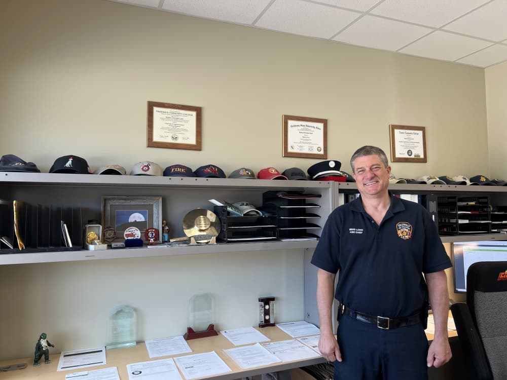 man standing in front of hats and awards