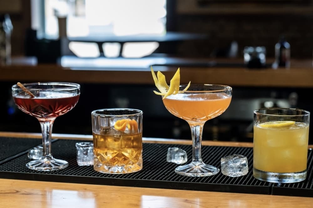 cocktails lined up on a bar