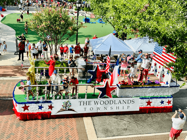 A large float proceeds down a street.