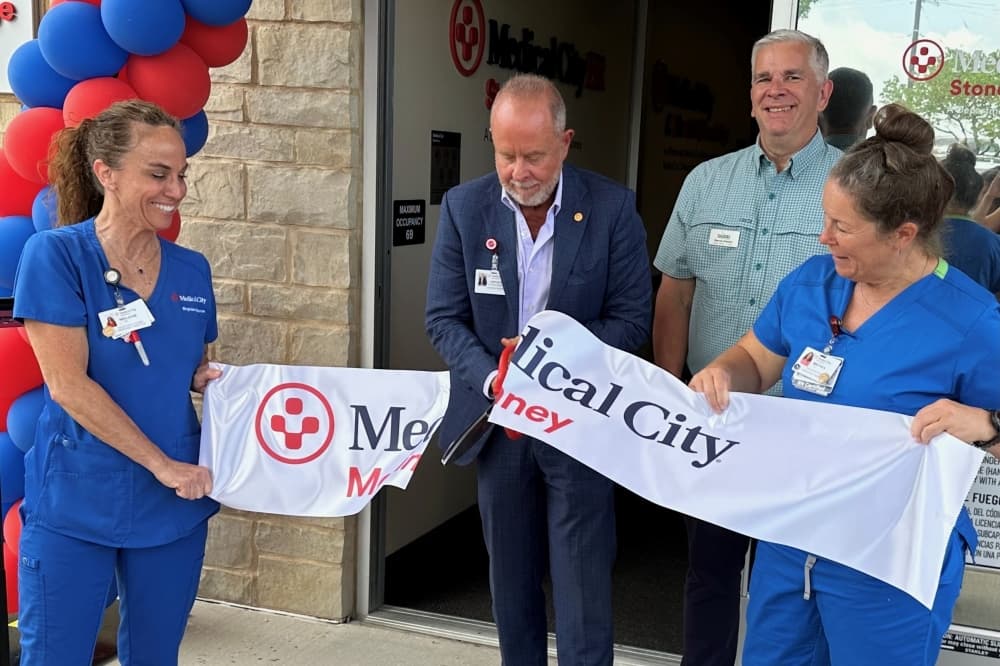Medical City official cuts the ribbon held by two nurses, also a McKinney city council member