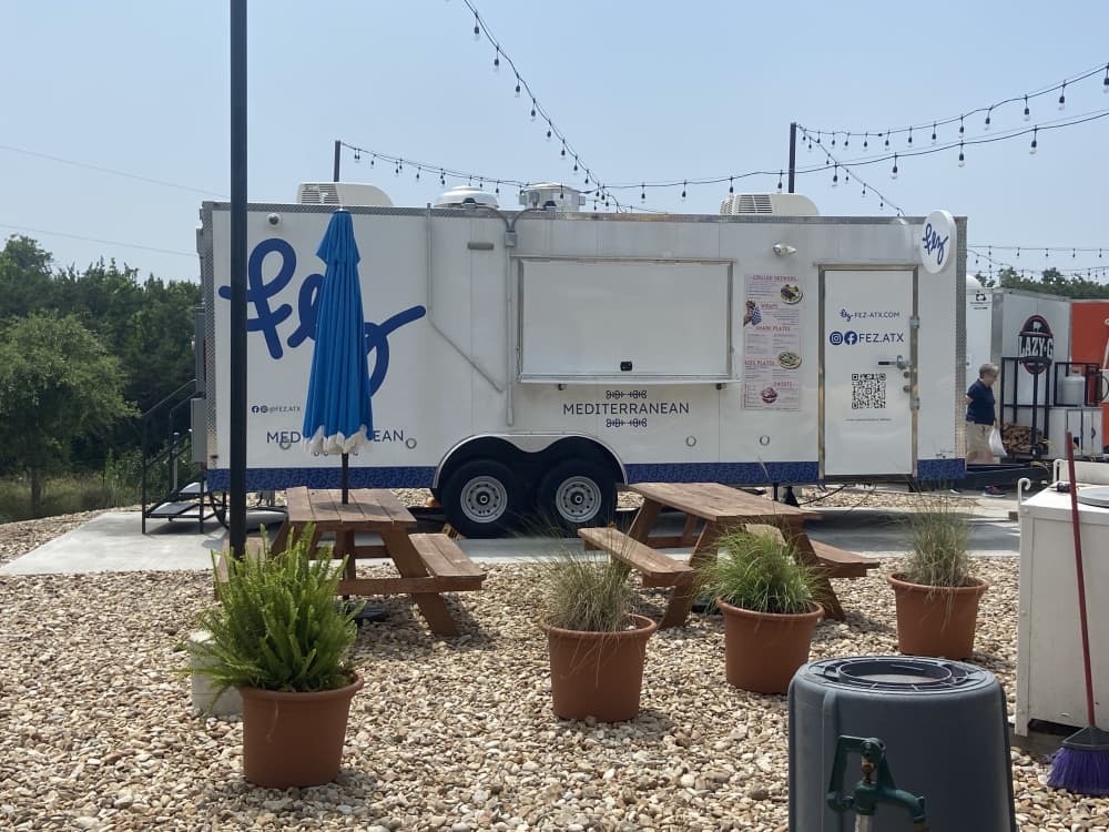 food truck with blue name "fez" and outdoor seating area 