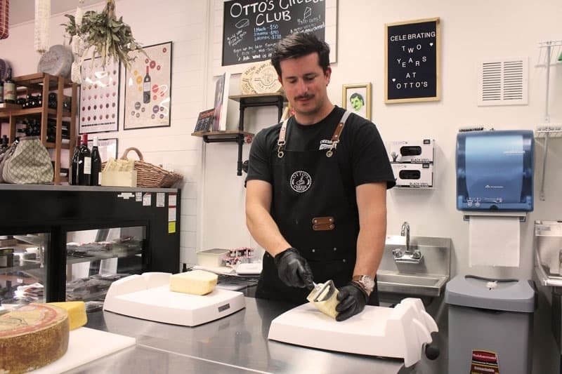 Bob Pineda cutting cheese in the shop. 