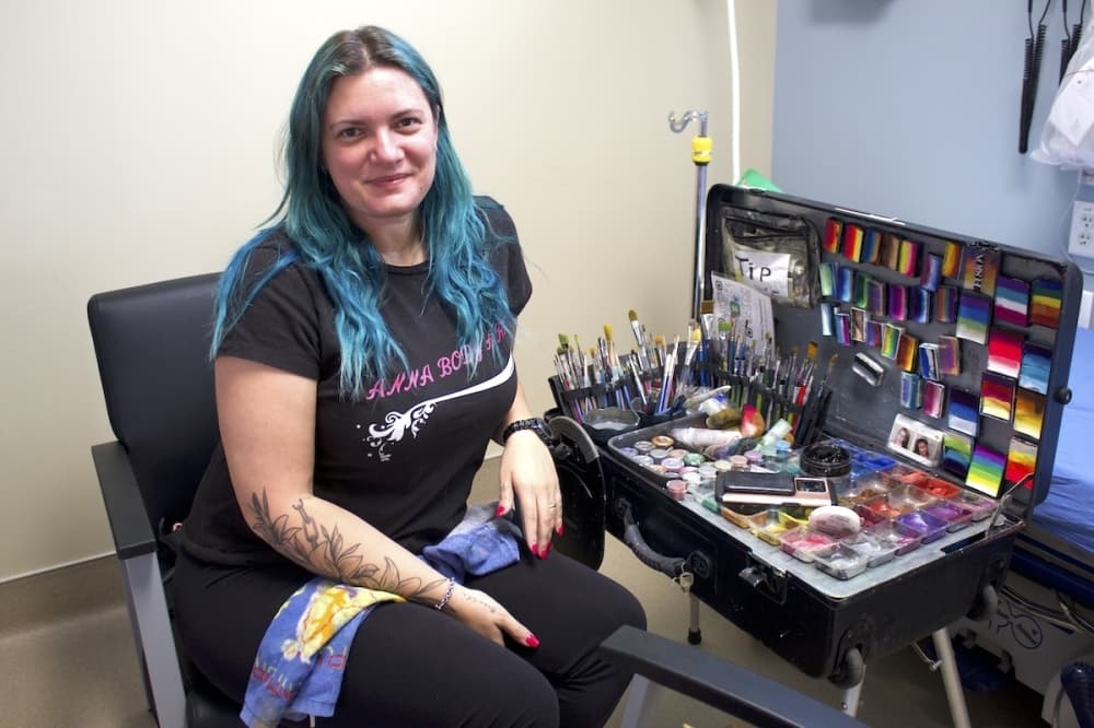 Local face and body artist Anna Chapovalov sitting next to face painting tools.