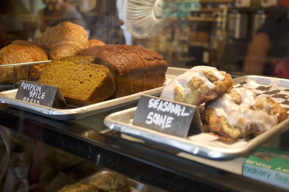 Scones and pumpkin bread behind glass. 