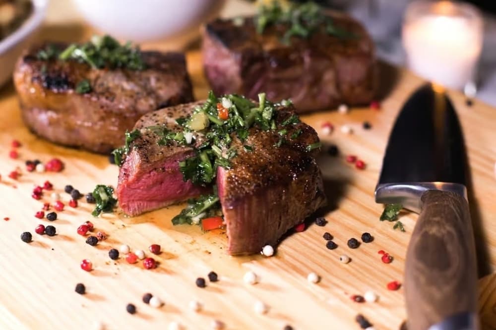 Filet mignon on cutting board topped with herbs (Courtesy Avenida Brazil)
