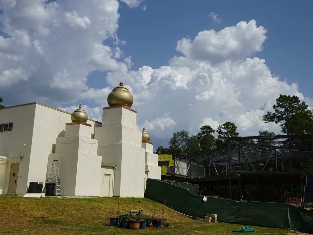 The exterior of a temple building with a portion under construction