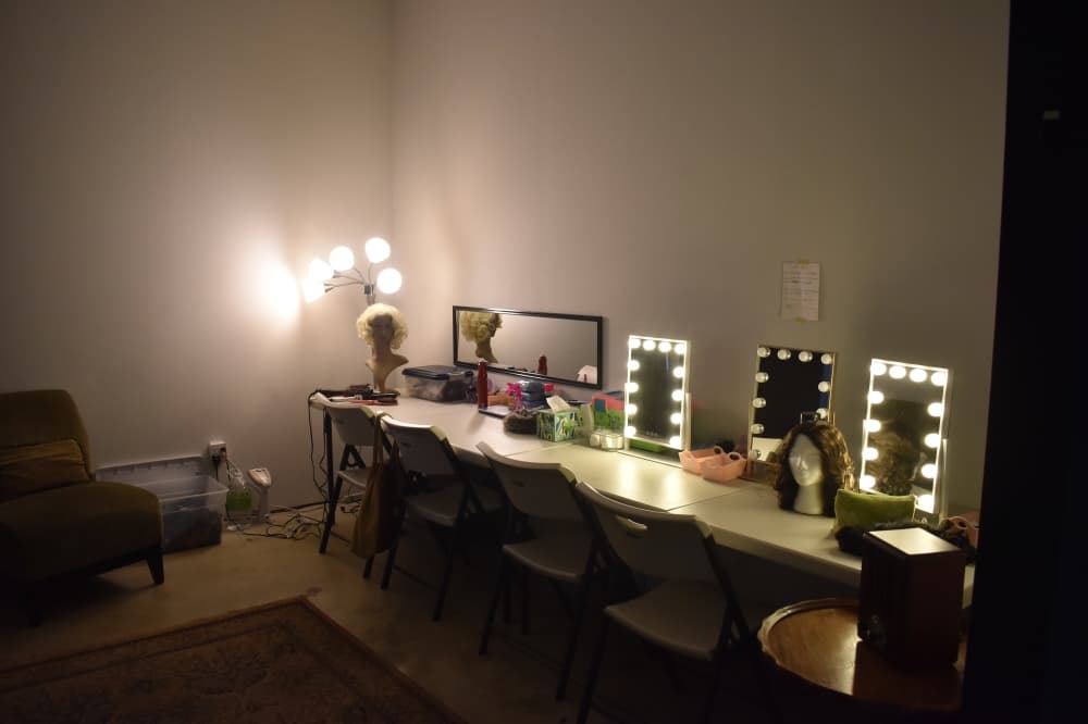 A backstage area with a table that has mirrors on it 