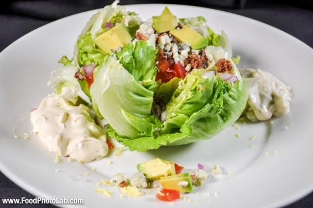 Marais' Classic Wedge Salad - A salad that comes with roquefort blue cheese and blue cheese dressing, bacon crumbles, diced tomato and avocado. Comes with add-on options too. (Courtesy Marais)