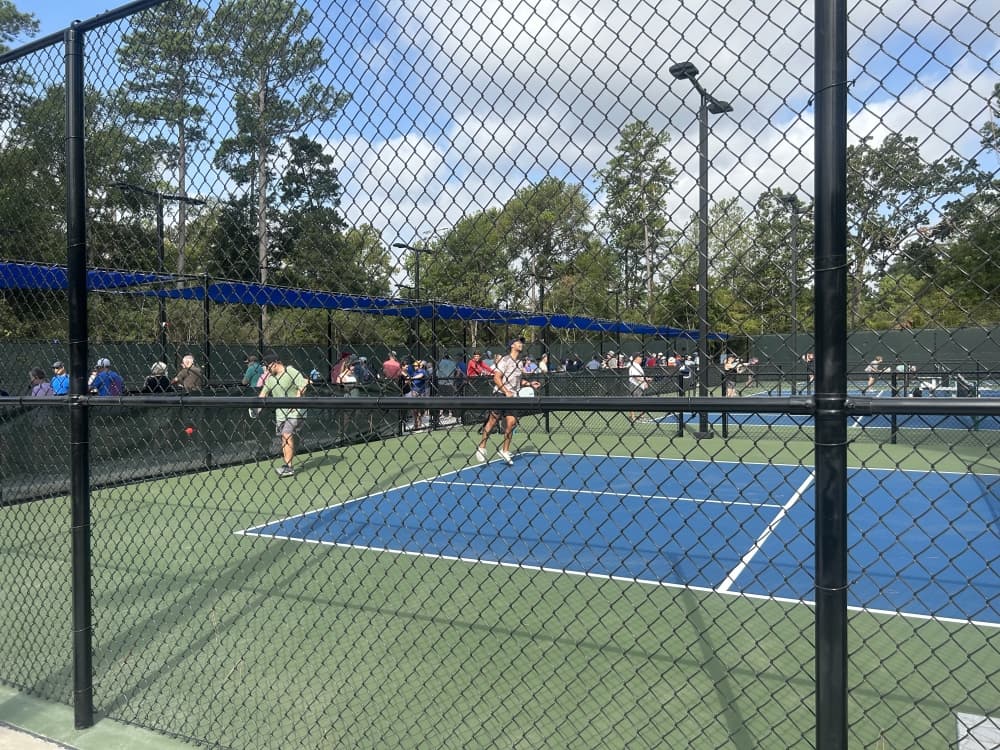Pickleball court seen through a fence