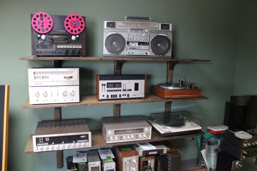 A shelf with several pieces of vintage audio equipment. 