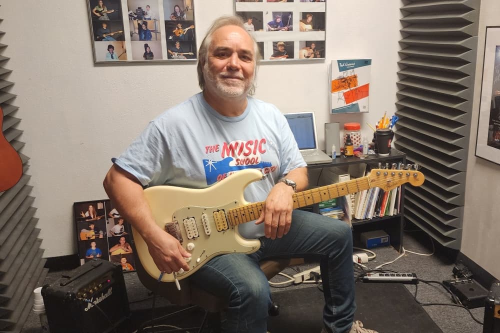 Art Villarreal holding a guitar.