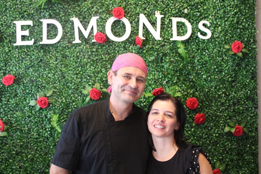 Edmond and Aida Lamce embrace each other inside their restaurant. 