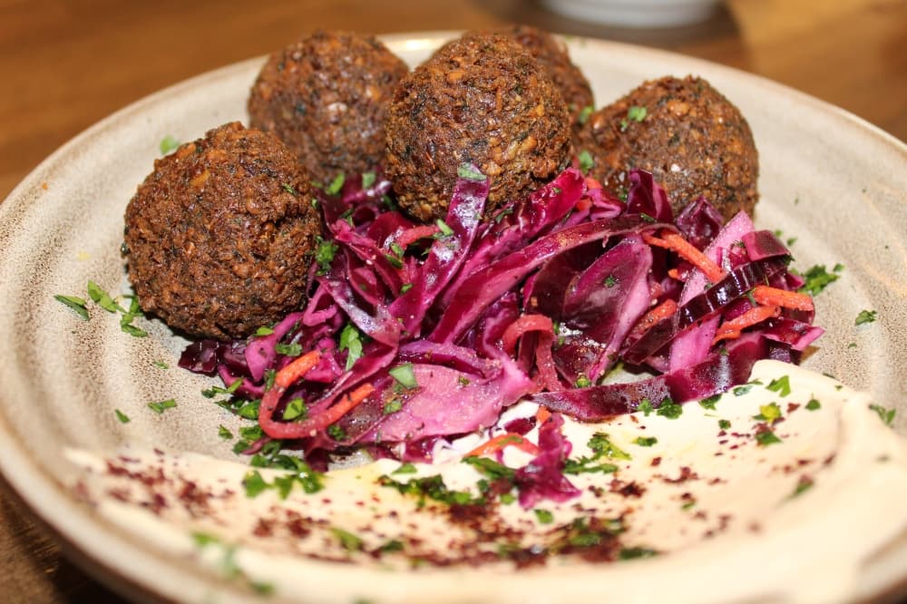 On the restaurant’s dinner menu is falafel ($15), which is served with tahini sauce and a red cabbage salad. (Melissa Enaje/Community Impact)