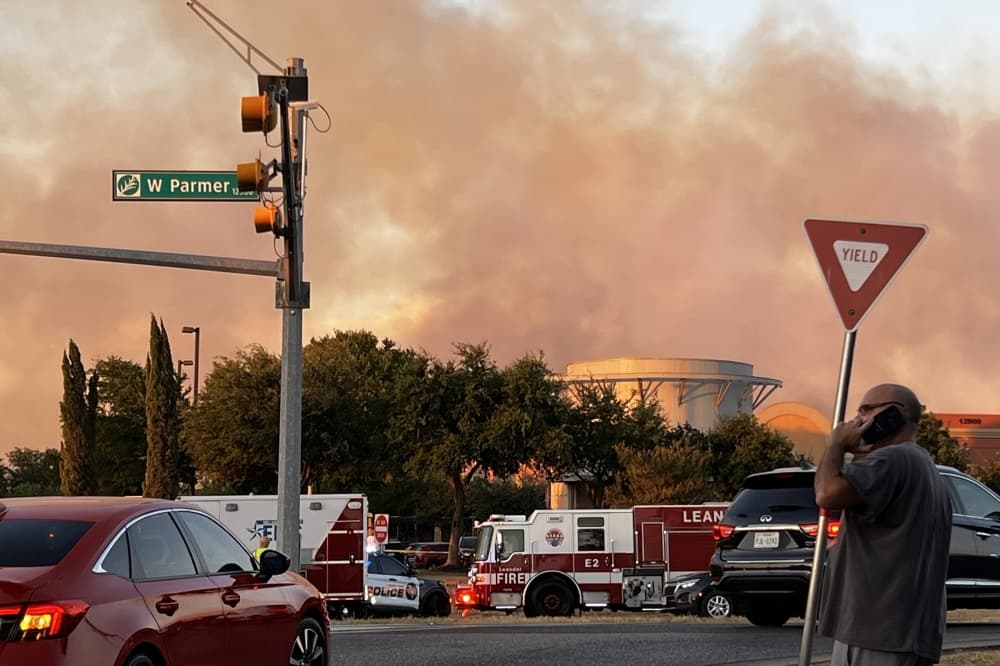 man on phone with fire in background 