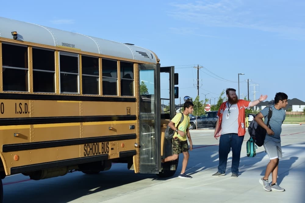 Students hop off the bus and head into Wilkinson Middle School for the first day of classes Aug. 9. (Hannah Johnson/Community Impact)