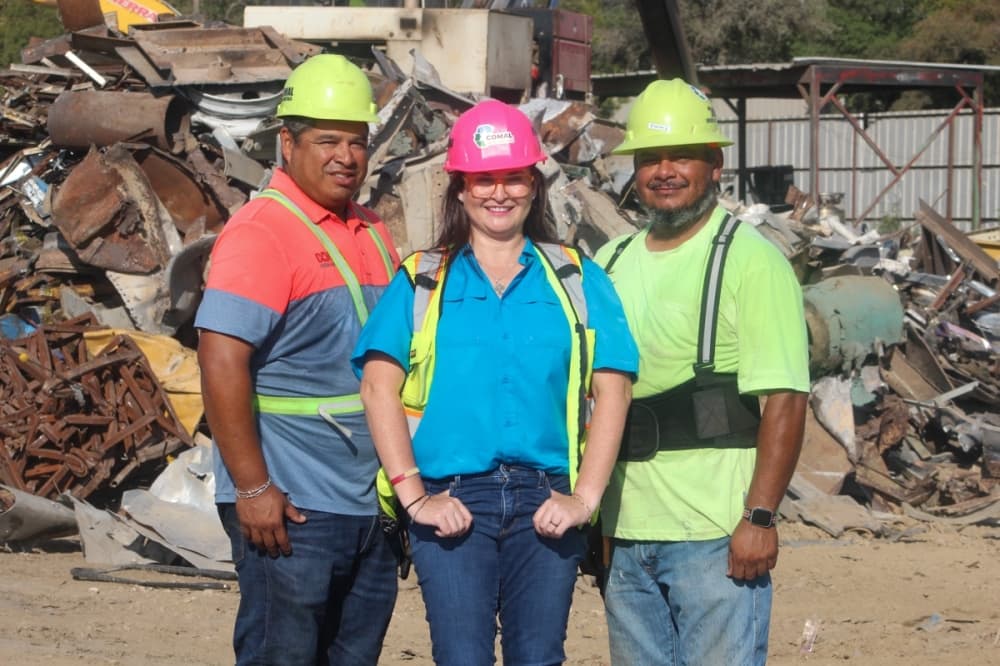 (From left) Johnnie Jr., Marcela and Roger Rodriguez stand together at the recycling site. (Photo by Amira Van Leeuwen/Community Impact)