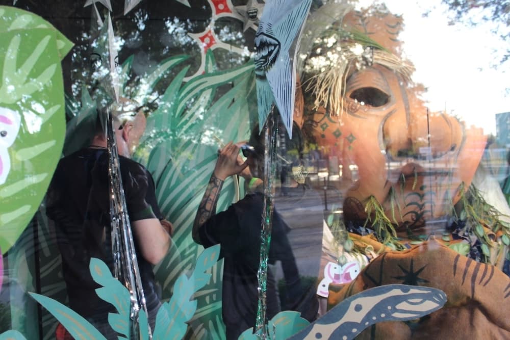 This is a photo of artist Kill Joy working on her window display.