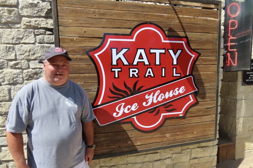 Owner Buddy Cramer stands in front of sign at Katy Trail Icehouse in Dallas. 