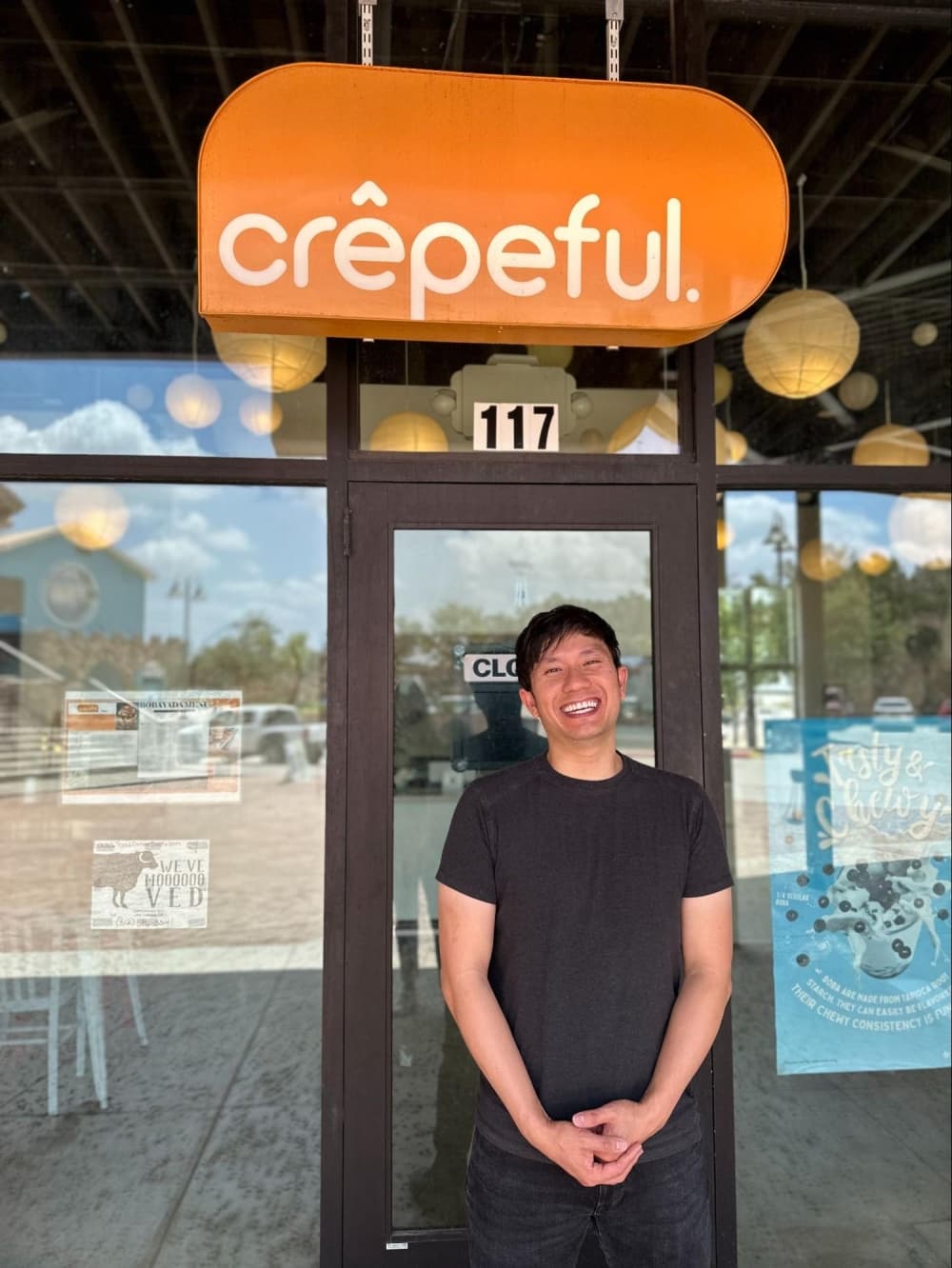 The owner stands in front of the eatery front door