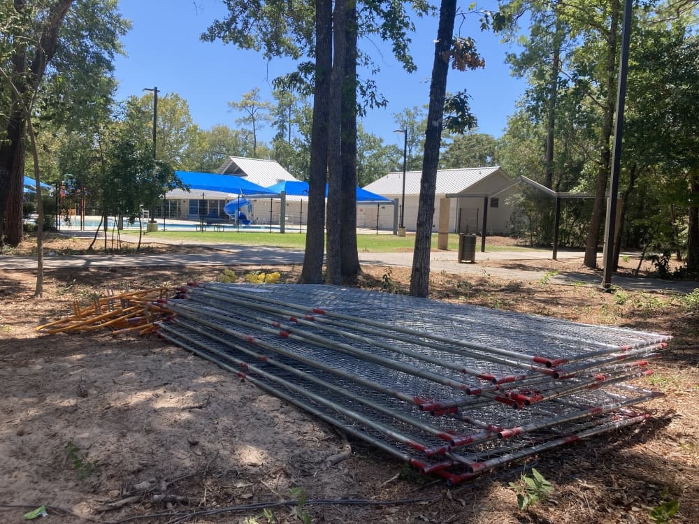 Fencing is piled at a work site in a park.