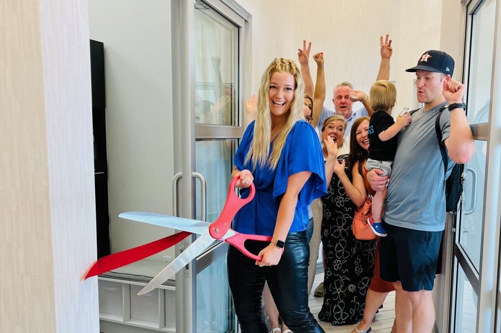 HairWeavon owner Ariel Rawlings cuts the ribbon on her shop entrance for the grand opening 